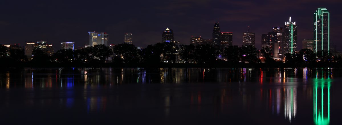 The Dallas, Texas skyline at night reflected over the Trinity River